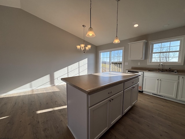 kitchen featuring lofted ceiling, a kitchen island, a sink, and dark wood finished floors