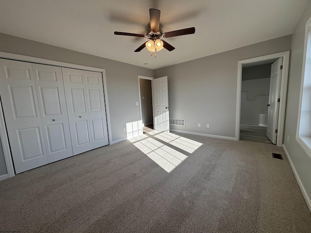 unfurnished bedroom with a closet, carpet, visible vents, and baseboards