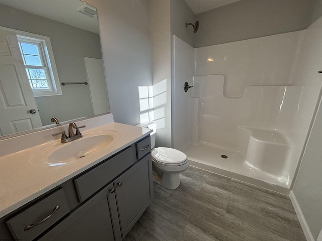 bathroom featuring toilet, visible vents, walk in shower, and wood finished floors