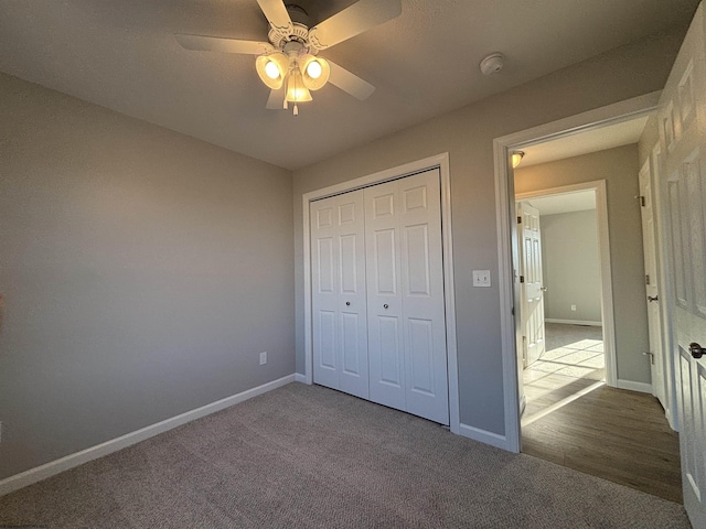 unfurnished bedroom featuring carpet floors, a closet, and baseboards