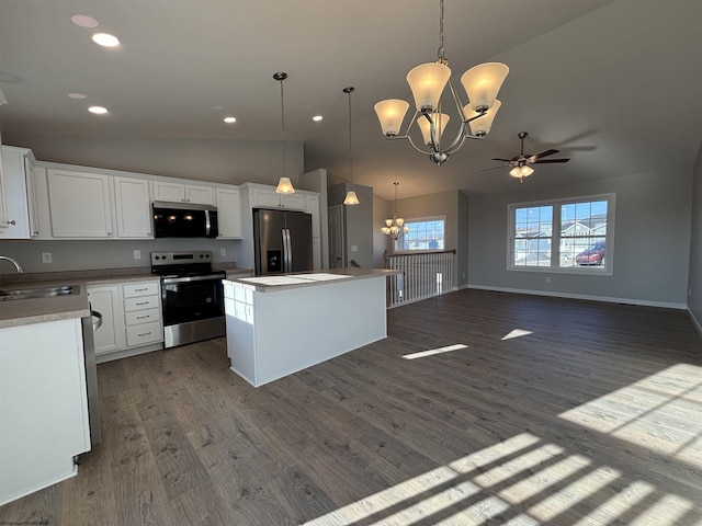 kitchen featuring dark wood finished floors, stainless steel appliances, a sink, and a center island