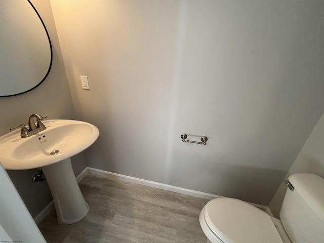 bathroom featuring wood finished floors, toilet, and baseboards