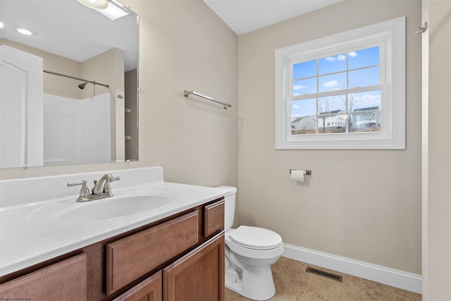 bathroom with visible vents, toilet, vanity, baseboards, and walk in shower