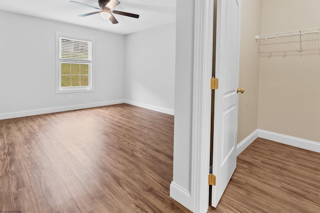 spare room with a ceiling fan, baseboards, and wood finished floors