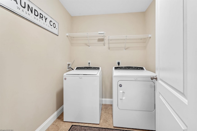 washroom with washing machine and dryer, laundry area, and baseboards