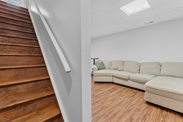 interior space with a drop ceiling and wood finished floors