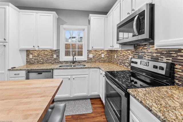 kitchen featuring decorative backsplash, dark wood-type flooring, stainless steel appliances, white cabinetry, and a sink