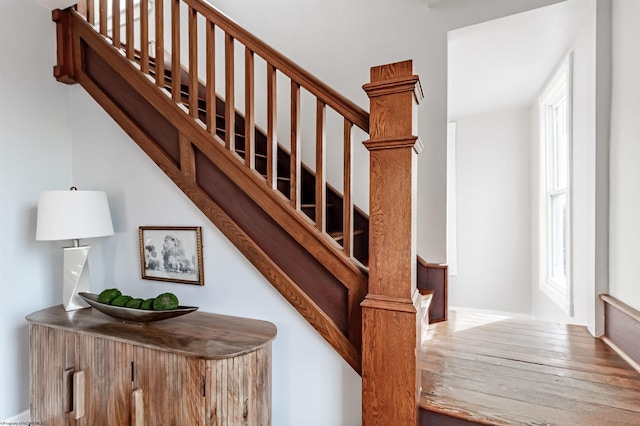 staircase with a wealth of natural light and wood finished floors