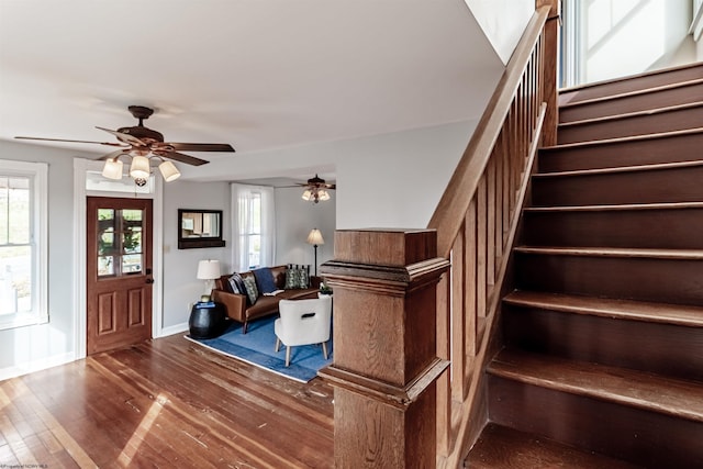 interior space featuring ceiling fan, stairs, baseboards, and wood finished floors