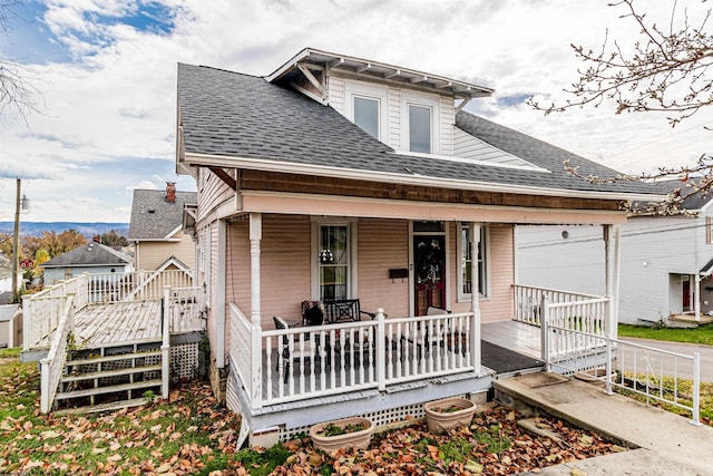 view of front of home featuring a shingled roof and covered porch