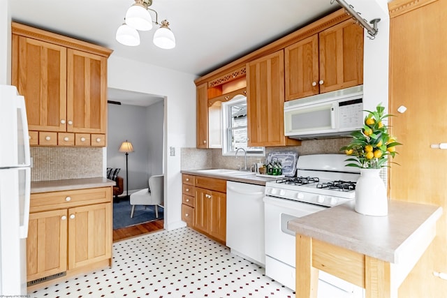 kitchen featuring white appliances, a sink, light countertops, light floors, and backsplash