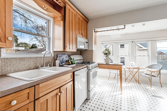 kitchen with white appliances, a sink, and tasteful backsplash