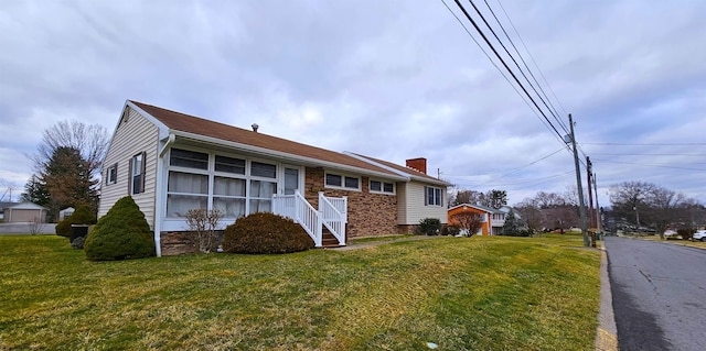 view of front of house featuring a front lawn and a chimney