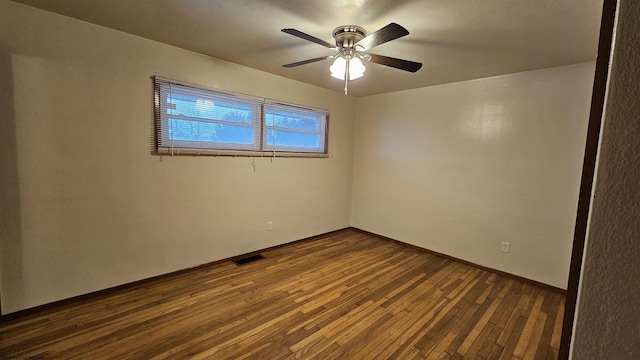 unfurnished room with dark wood-style floors, visible vents, and a ceiling fan