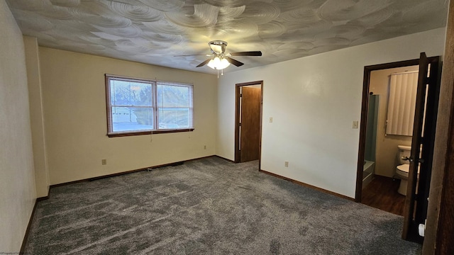 unfurnished bedroom with baseboards, dark colored carpet, and a ceiling fan