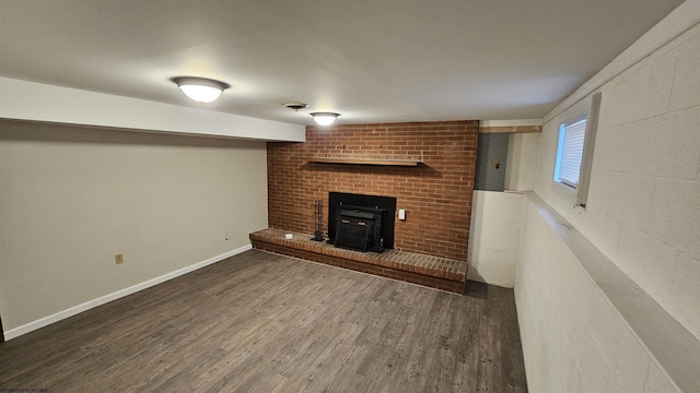 below grade area featuring a wood stove, baseboards, and wood finished floors