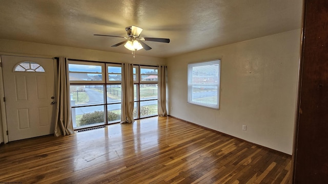 interior space with baseboards, hardwood / wood-style flooring, and a ceiling fan