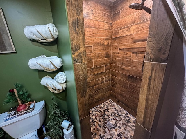 full bath featuring tiled shower and toilet