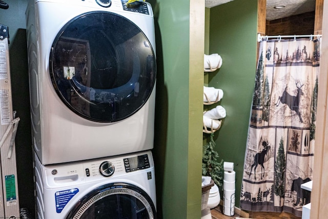 washroom featuring stacked washer / dryer and laundry area