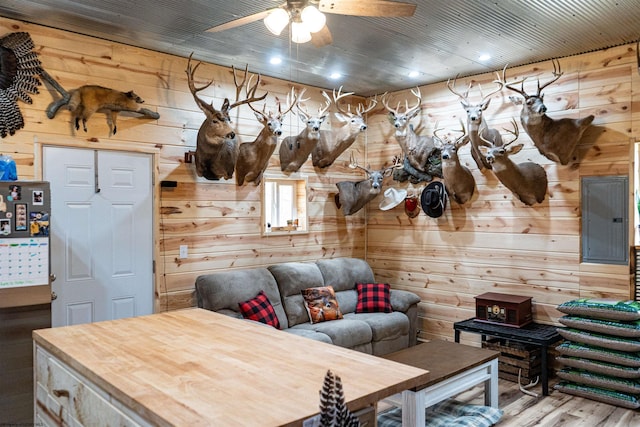 interior space with wood ceiling, wooden walls, ceiling fan, and wood finished floors