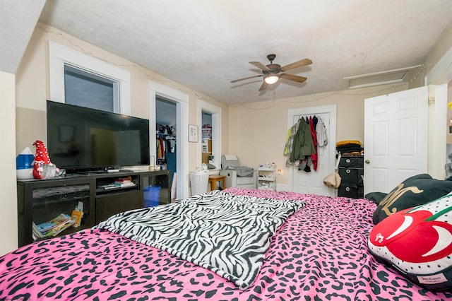 bedroom featuring a closet, attic access, and a ceiling fan