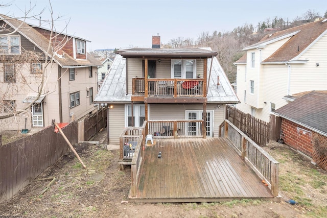 rear view of house with a fenced backyard, a chimney, and a wooden deck