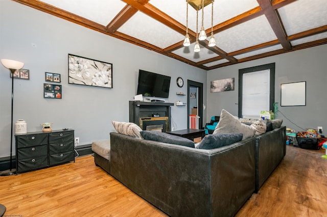 living room featuring light wood finished floors, coffered ceiling, a glass covered fireplace, beamed ceiling, and an inviting chandelier