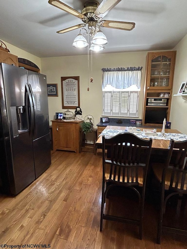 dining space with a ceiling fan and light wood-style flooring