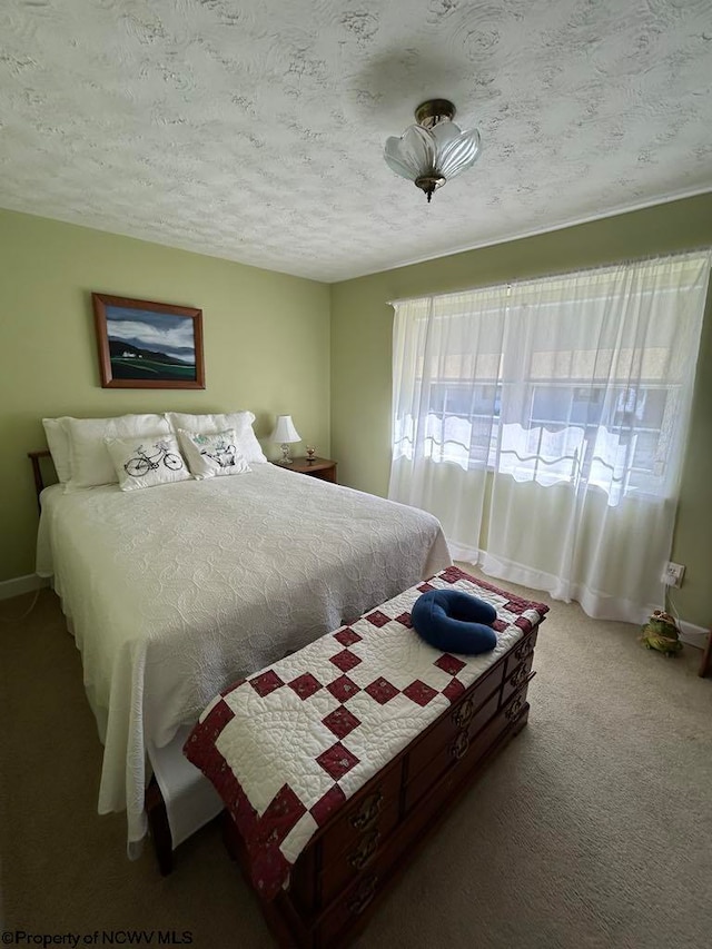 carpeted bedroom featuring a textured ceiling and baseboards