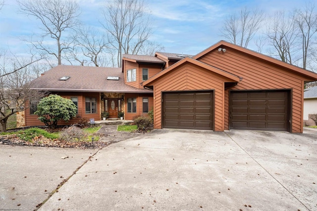 view of front of home with concrete driveway, roof with shingles, and an attached garage