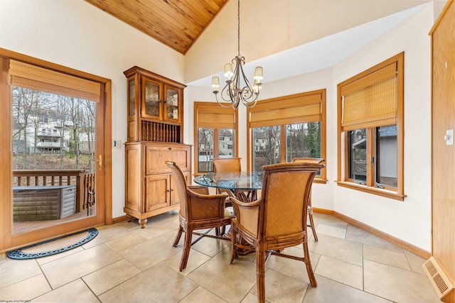 dining space featuring a chandelier, light tile patterned floors, lofted ceiling, visible vents, and baseboards