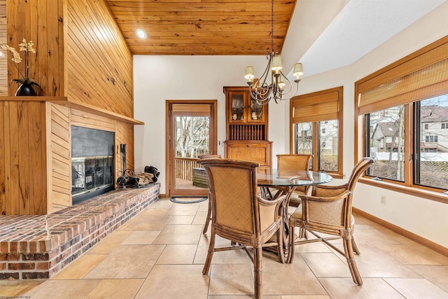 dining room with high vaulted ceiling, wooden ceiling, a notable chandelier, a large fireplace, and baseboards