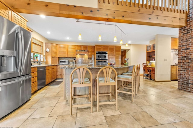 kitchen with appliances with stainless steel finishes, a breakfast bar area, light stone countertops, extractor fan, and a sink