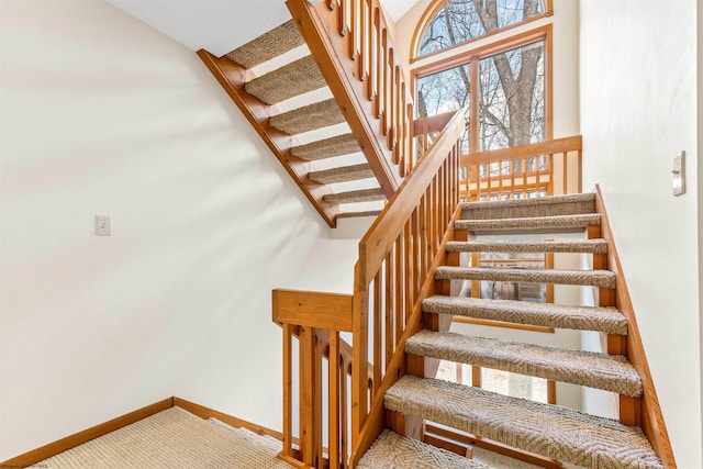 stairway featuring carpet and baseboards