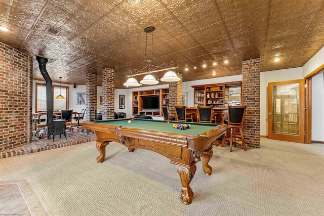 recreation room featuring a dry bar, billiards, brick wall, a wood stove, and carpet