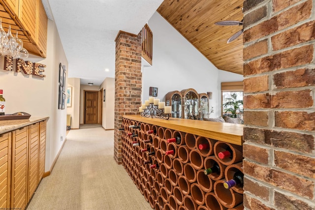 wine room featuring decorative columns, light colored carpet, wood ceiling, ceiling fan, and baseboards