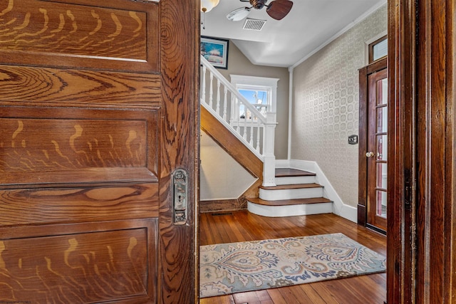 entryway featuring hardwood / wood-style flooring, visible vents, stairway, baseboards, and wallpapered walls