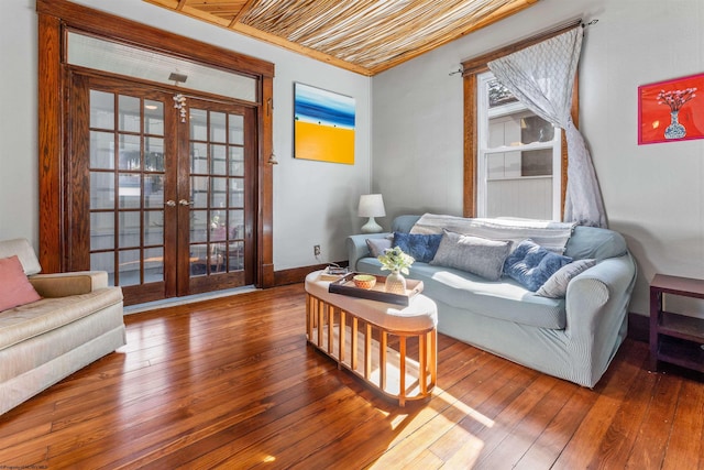 living room featuring hardwood / wood-style flooring, baseboards, ornamental molding, and french doors