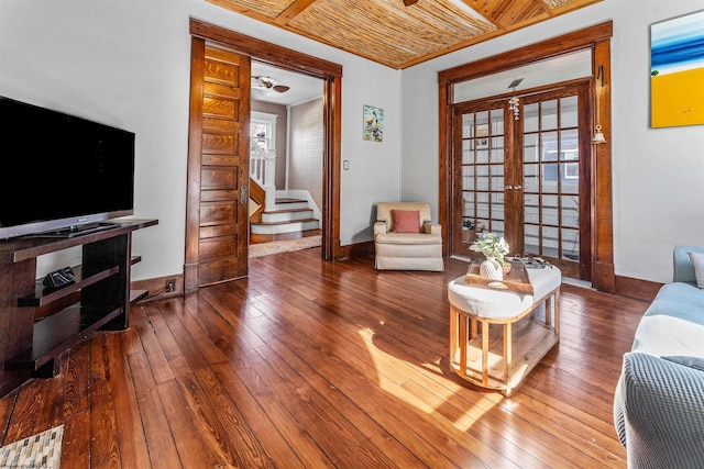 living area with a wealth of natural light, wood-type flooring, and stairway