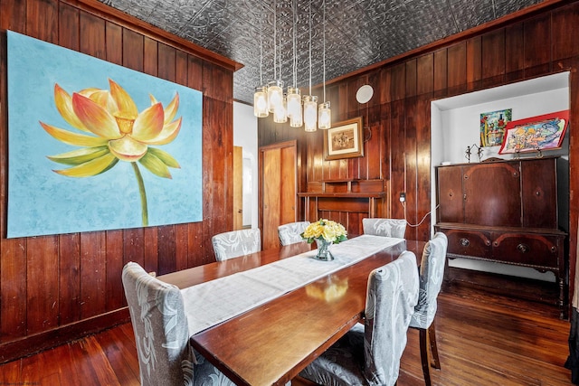 dining room with an ornate ceiling, wooden walls, and wood-type flooring