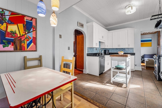 kitchen with arched walkways, dark countertops, decorative backsplash, white cabinetry, and tile patterned floors