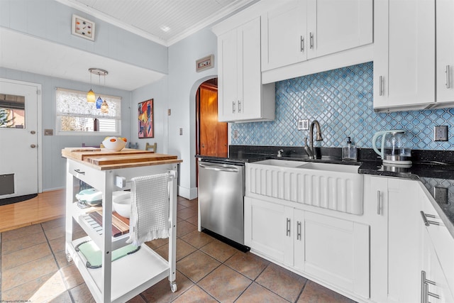 kitchen with arched walkways, stainless steel dishwasher, backsplash, and white cabinets