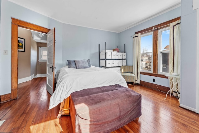 bedroom featuring attic access, baseboards, and wood-type flooring