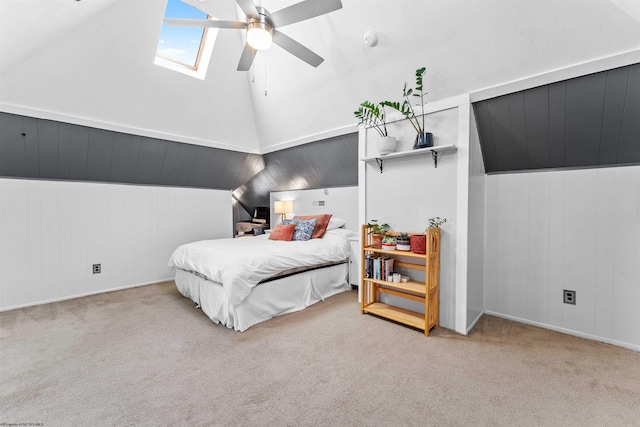 bedroom with ceiling fan, high vaulted ceiling, a skylight, and carpet flooring