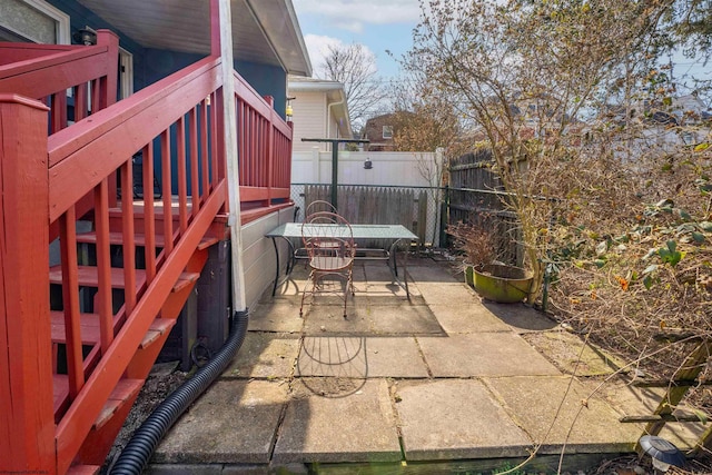 view of patio / terrace featuring stairs, outdoor dining area, and fence