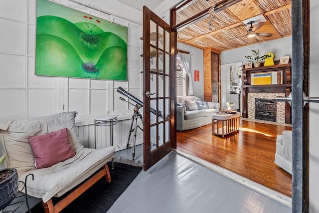 living area featuring a fireplace, hardwood / wood-style floors, and ceiling fan