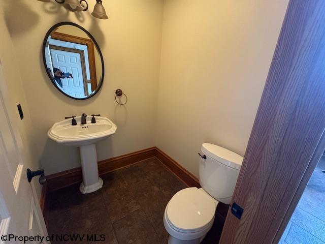 bathroom featuring toilet and baseboards