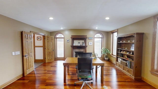 office space with lofted ceiling, plenty of natural light, a fireplace, and wood finished floors