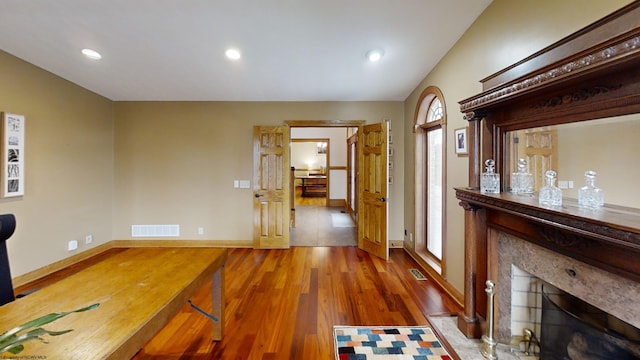 interior space featuring visible vents, a fireplace, baseboards, and wood finished floors