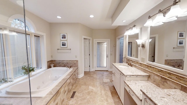 full bathroom with visible vents, baseboards, a tub with jets, vanity, and recessed lighting